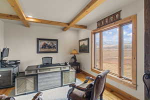 Office with beamed ceiling, coffered ceiling, and light hardwood / wood-style flooring