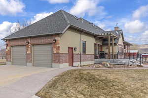 View of side of home with a garage and a yard