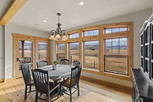 Dining room featuring a wealth of natural light, an inviting chandelier, and light hardwood / wood-style flooring