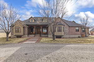 View of front facade featuring a front yard and covered porch