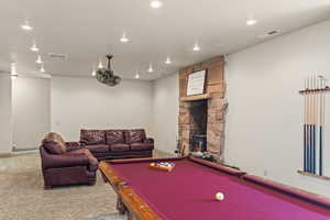 Recreation room featuring pool table, a fireplace, and carpet flooring