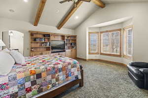 Carpeted bedroom with vaulted ceiling with beams and ceiling fan