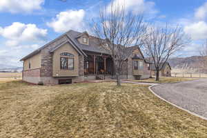 View of front of home with a mountain view and a front lawn