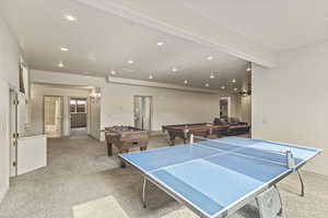 Recreation room with pool table and light colored carpet