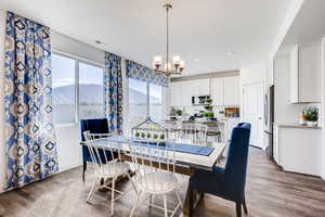 Dining space with an inviting chandelier, wood-type flooring, and a mountain view