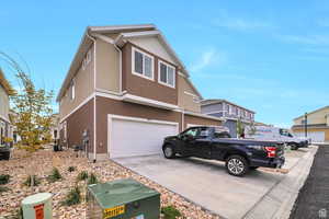 View of front facade featuring central AC unit and a garage