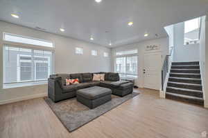 Living room featuring plenty of natural light, a textured ceiling, and light hardwood / wood-style flooring