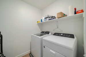 Laundry area featuring wood-type flooring and washer and dryer