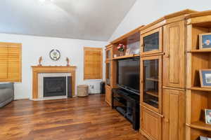 Living room featuring vaulted ceiling, fireplace, hardwood floors and ceiling fan