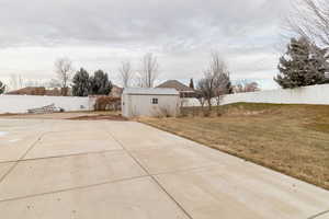 View of back of the house featuring shed and backyard