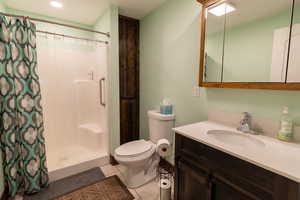 Bathroom featuring tile flooring, vanity, and walk in shower