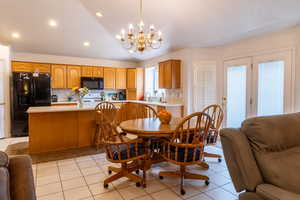 Dining room featuring chandelier, tile floor and French doors