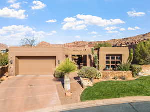 Pueblo-style house featuring a garage and a mountain view