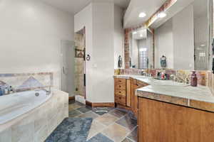 Bathroom featuring vanity and separate shower and tub