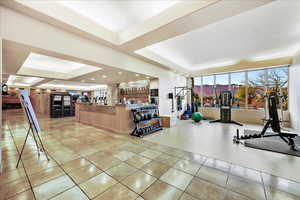 Interior space with a raised ceiling and light tile patterned floors