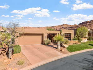 Pueblo-style home with a garage and a mountain view