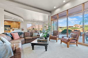 Carpeted living room featuring a notable chandelier