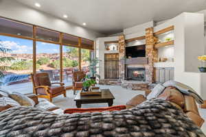 Carpeted living room with a stone fireplace