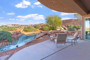 View of patio / terrace featuring falls, mountain view and an outdoor fire pit