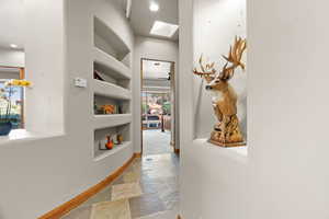 Corridor with built in shelves and a skylight