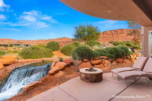 View of patio with a mountain view and a fire pit