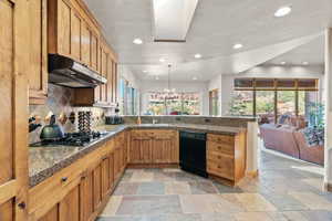 Kitchen with pendant lighting, sink, dishwasher, backsplash, and stainless steel gas cooktop