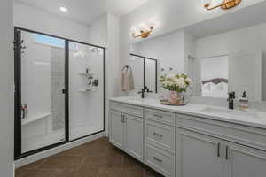 Bathroom featuring vanity, tile patterned floors, and a shower with door