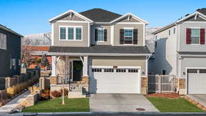 Craftsman-style house with a garage, a mountain view, and a front lawn