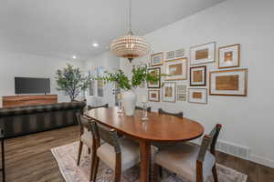 Dining room featuring dark wood-type flooring and a chandelier