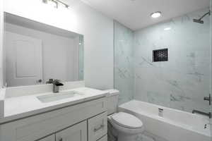 Full bathroom featuring vanity, toilet, and tiled shower / bath