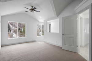 Carpeted empty room featuring lofted ceiling and ceiling fan