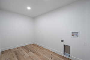 Laundry room featuring hookup for a washing machine, electric dryer hookup, and light hardwood / wood-style floors