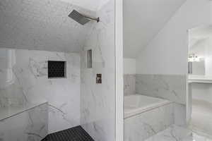 Bathroom featuring lofted ceiling and separate shower and tub