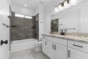 Full bathroom with vanity, toilet, and tiled shower / bath combo