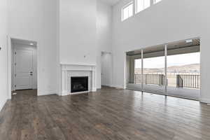 Unfurnished living room with dark hardwood / wood-style flooring, a mountain view, and a brick fireplace