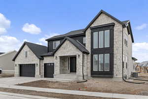 View of front facade with cooling unit and a garage