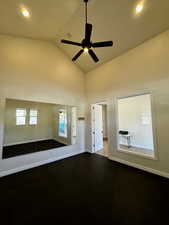 Unfurnished room with high vaulted ceiling and ceiling fan