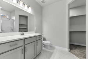 Bathroom with vanity, toilet, and a shower with shower door