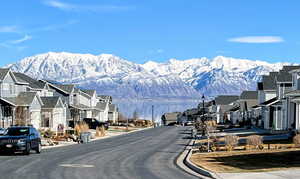 View of street featuring a mountain view, curbs, street lights, and a residential view