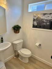 Bathroom with hardwood / wood-style flooring and toilet