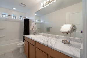 Full bathroom featuring vanity, toilet, tile patterned flooring, and shower / bath combo with shower curtain