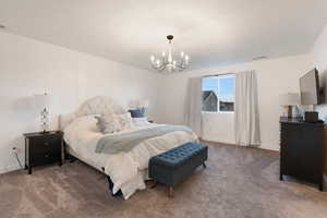 Carpeted bedroom featuring a notable chandelier