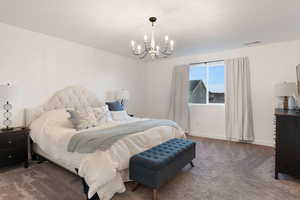 Carpeted bedroom with a notable chandelier