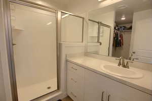 Bathroom featuring vanity and a shower with door