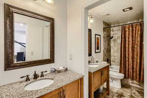 Full bathroom featuring vanity, shower / bathtub combination with curtain, and toilet