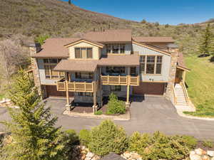 View of front facade featuring asphalt driveway, an attached garage, and a chimney