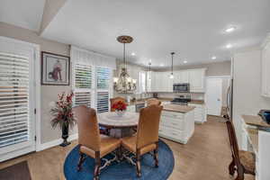 Dining space with an inviting chandelier, sink, and light hardwood / wood-style flooring