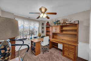 Home office with light carpet and ceiling fan