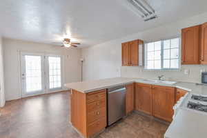 Kitchen with sink, ceiling fan, kitchen peninsula, stainless steel appliances, and a textured ceiling