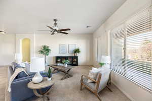 Living room featuring ceiling fan, plenty of natural light, and light carpet